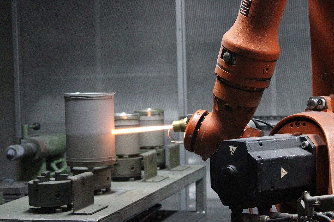 A robot-held thermal-spray gun coating cylindrical parts