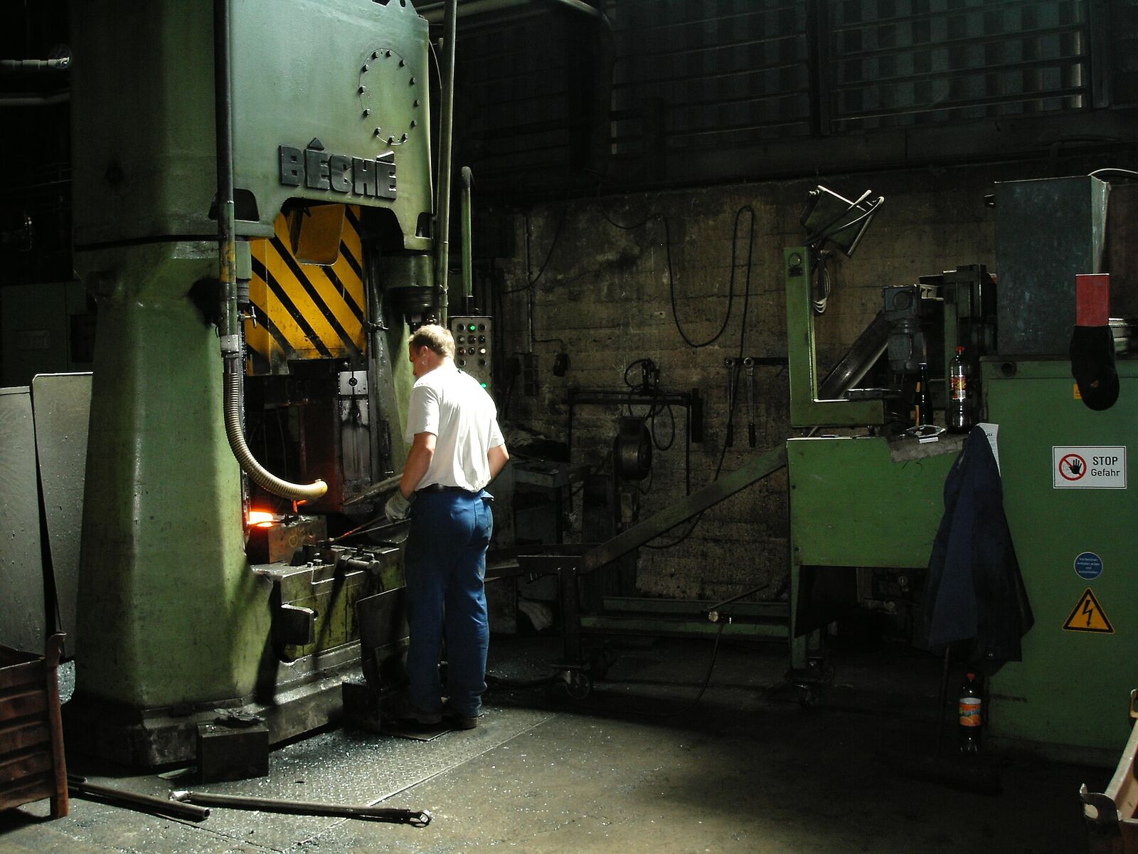 A forging press with a glowing part in a drop-forging shop