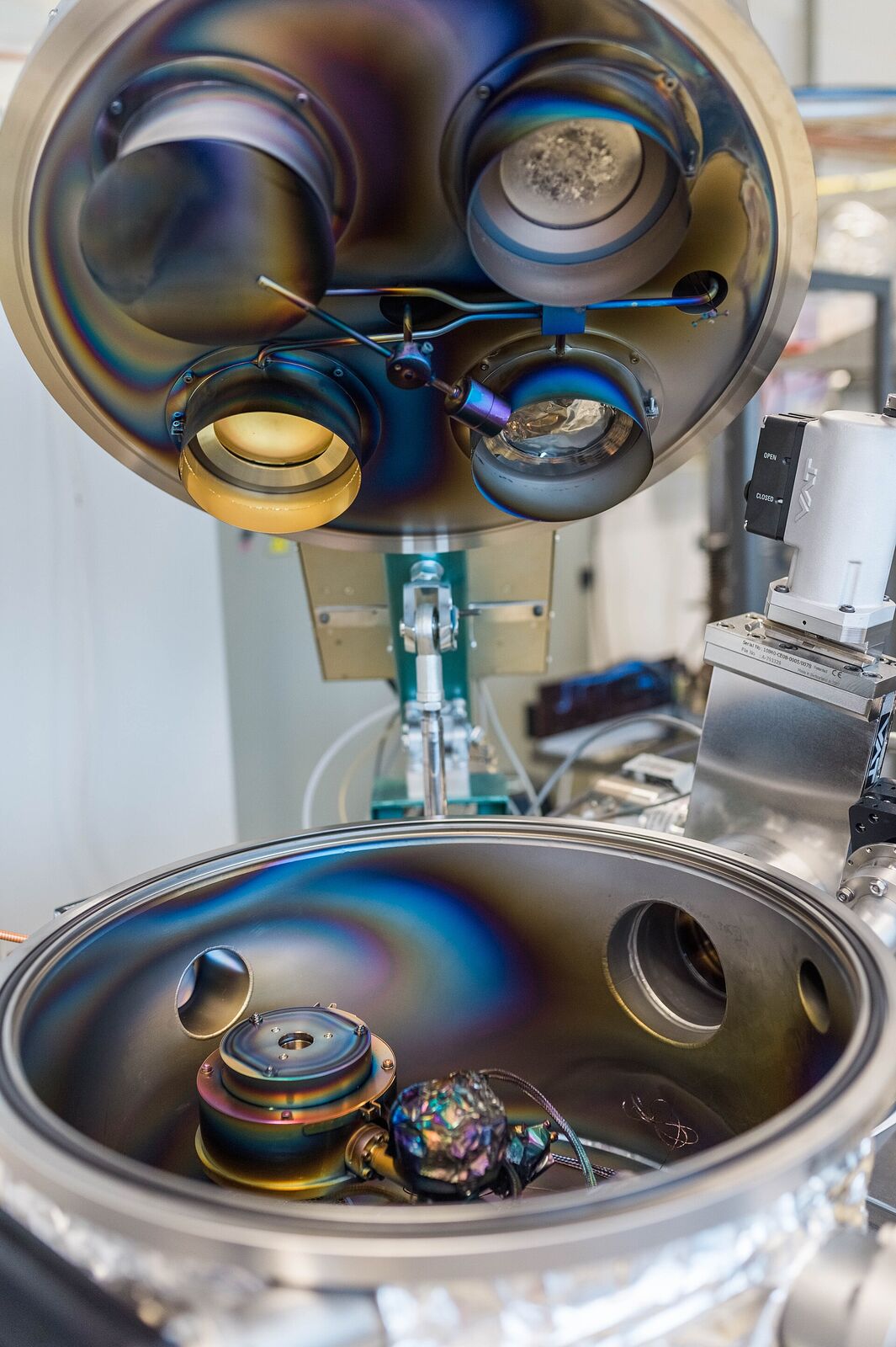An open magnetron sputtering chamber with rainbow-coloured coating deposits