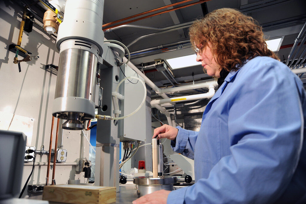 A technician loading a laser flash analyser in a materials-testing laboratory